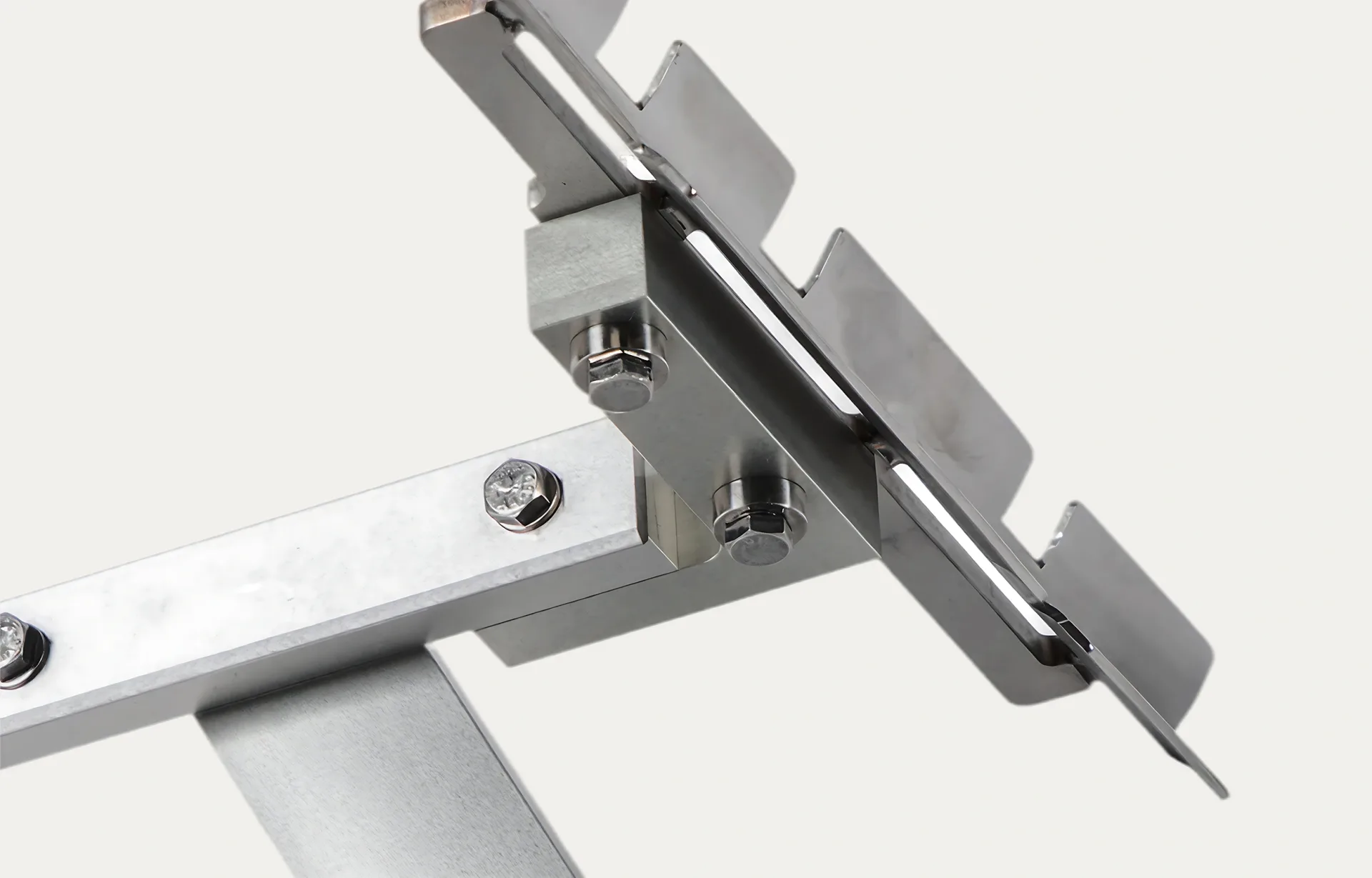 Close-up of a metal bracket with bolts and a serrated-edge design, suggesting functionality and industrial precision, against a plain background.