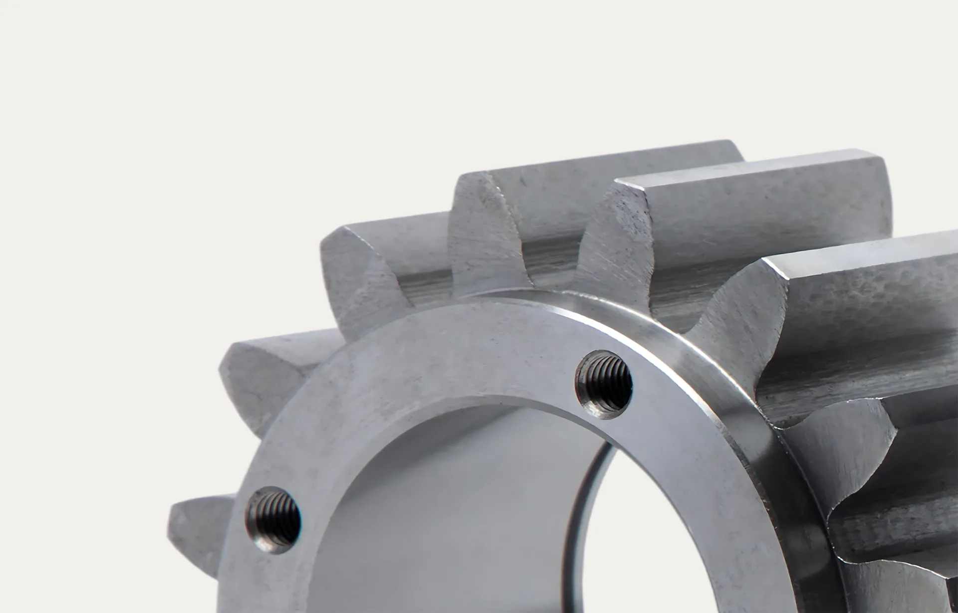 Close-up of a shiny, metallic gear with interlocking teeth, emphasizing its smooth surface and precise engineering. The tone is technical and industrial.