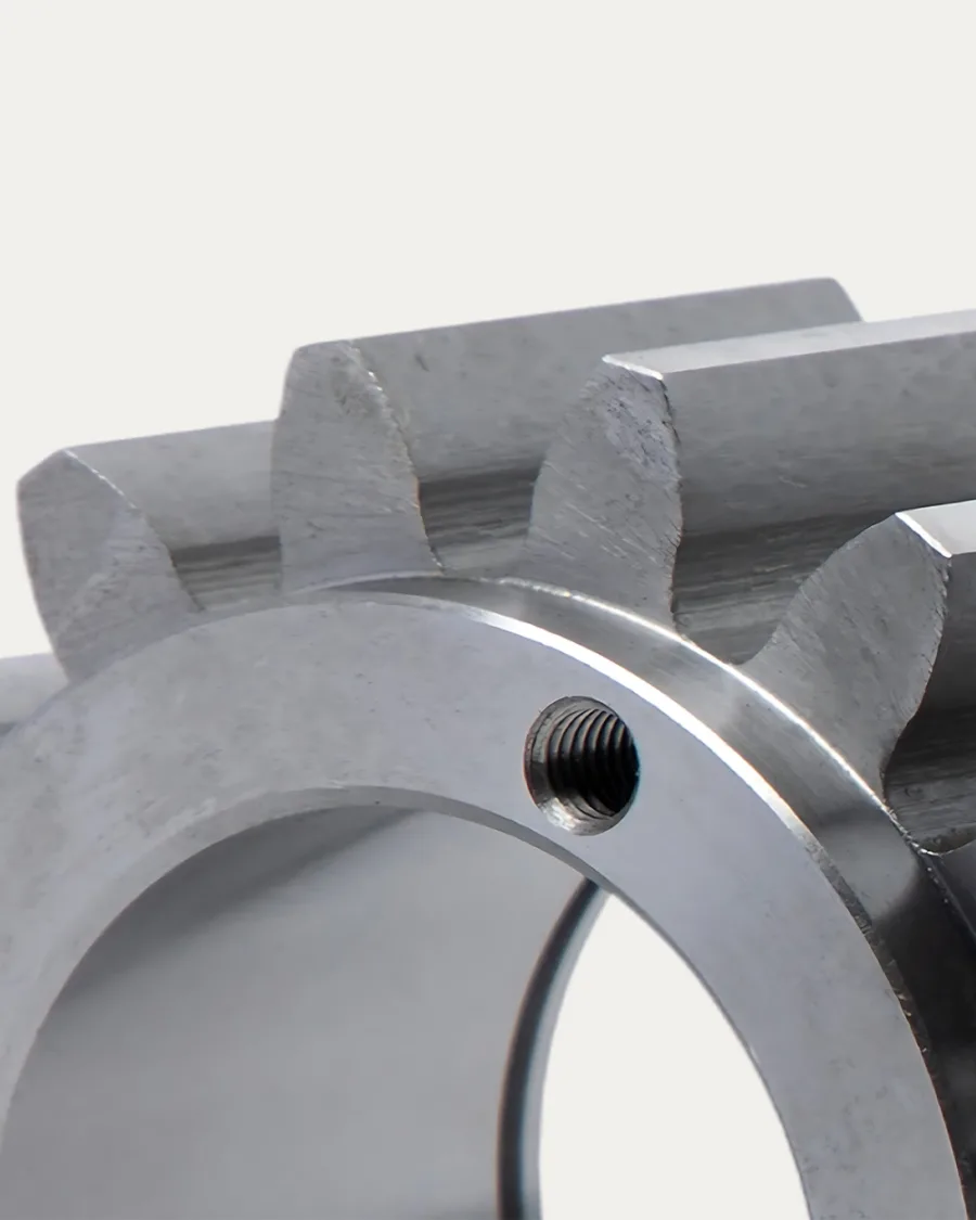 Close-up of a shiny, metallic gear with interlocking teeth, emphasizing its smooth surface and precise engineering. The tone is technical and industrial.