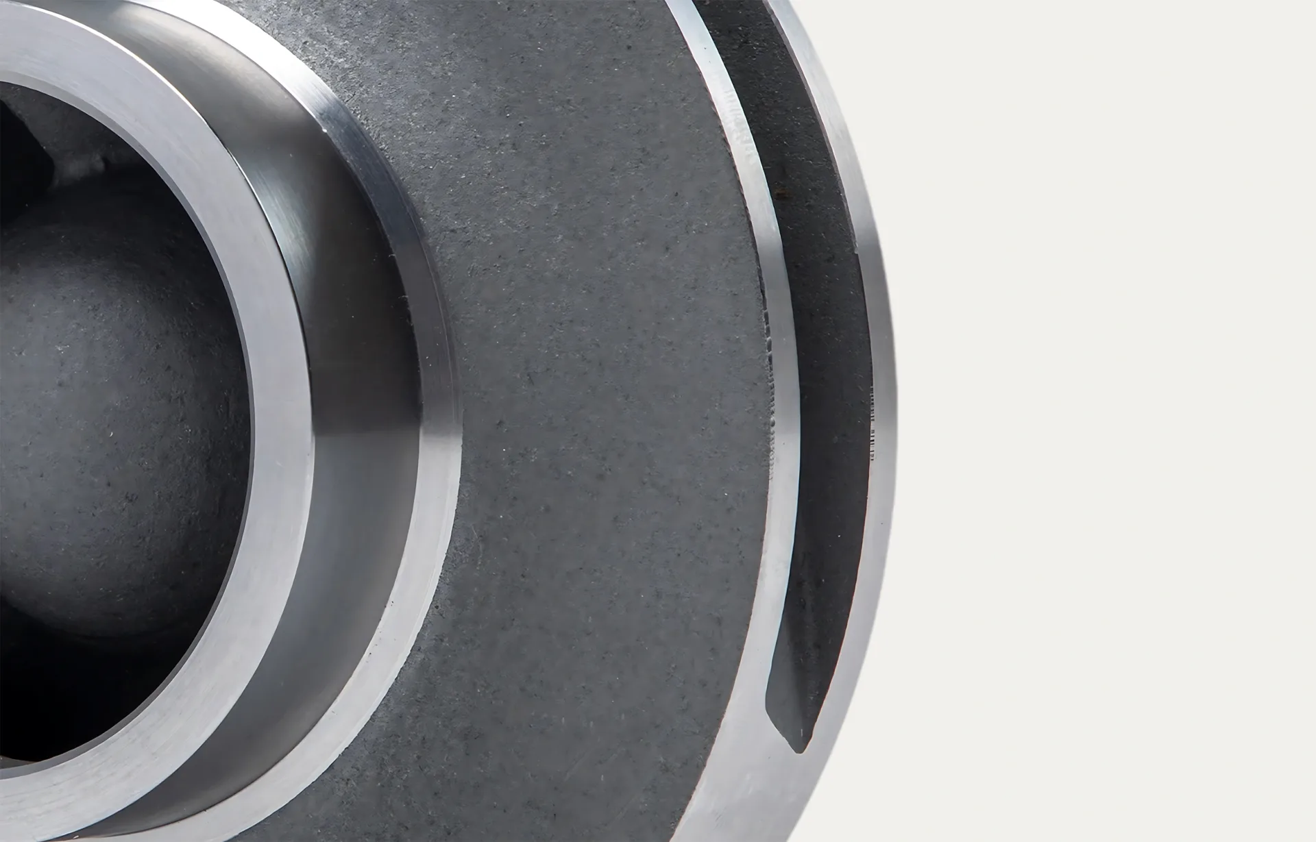 Close-up of a metallic, circular industrial component with grooved edges and smooth, polished surfaces. The image conveys a technical and precise tone.